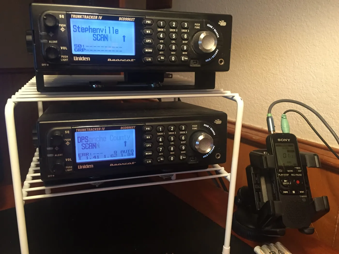 Two Uniden Bearcat scanners and a Sony recorder on a desk